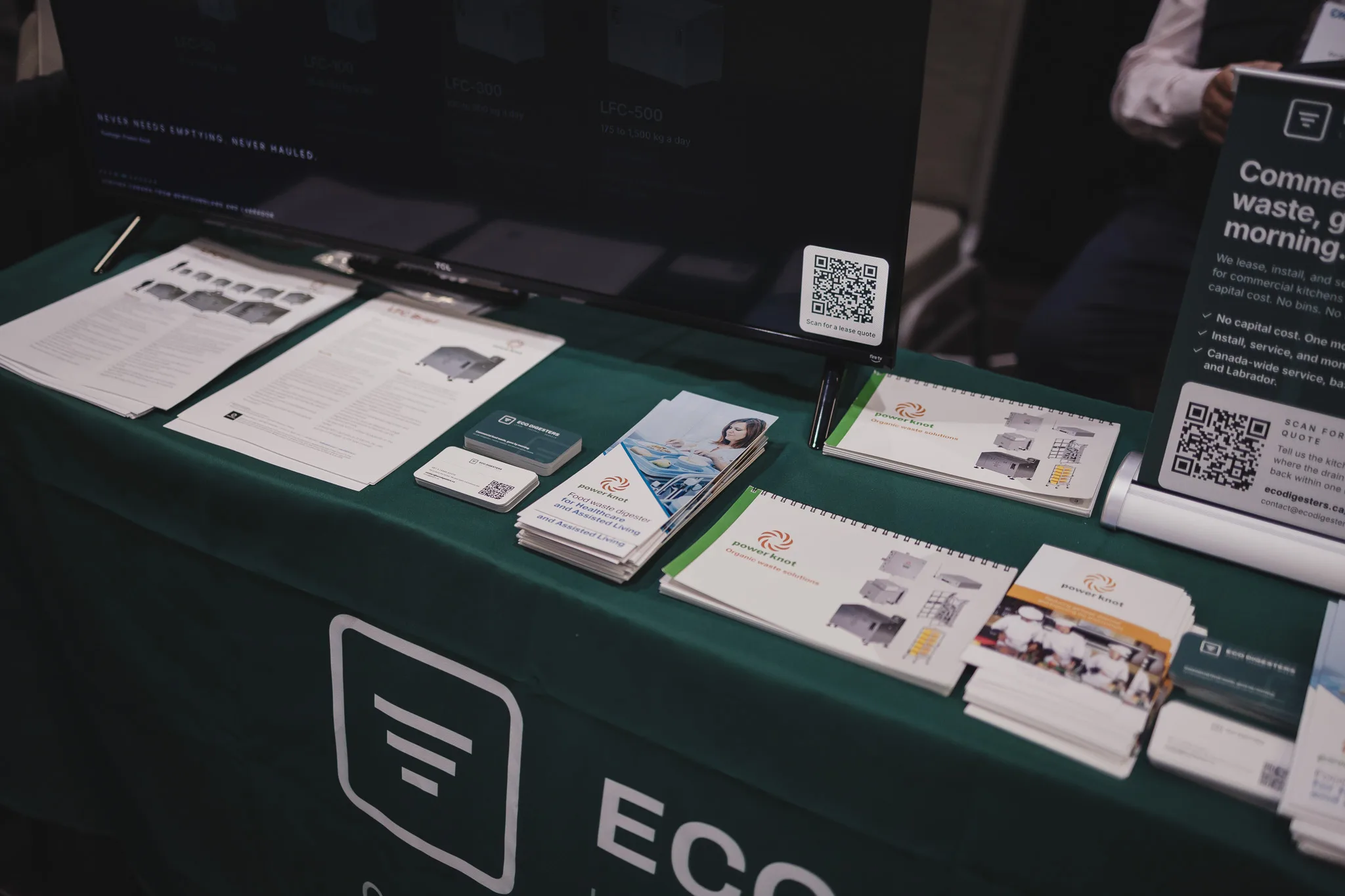 Power Knot brochures and product sheets, our business cards, and a code to scan for a lease quote, on our teal booth table.